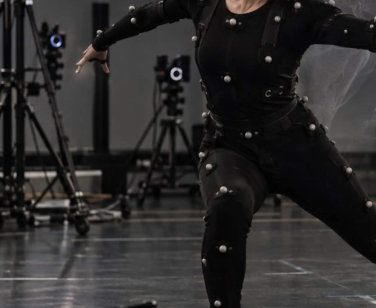 A performer in a motion-capture suit mid-movement on a studio stage